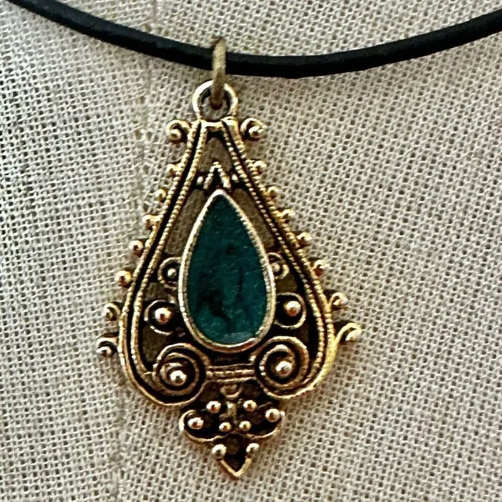 Green and gold tone pendant necklace on black cord